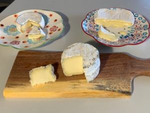 brie and camembert cheese wheels on plates